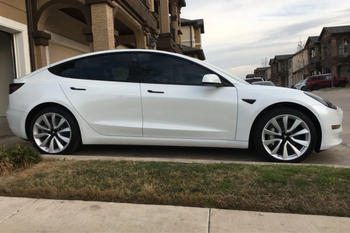 White car parked in residential driveway with tinted windows