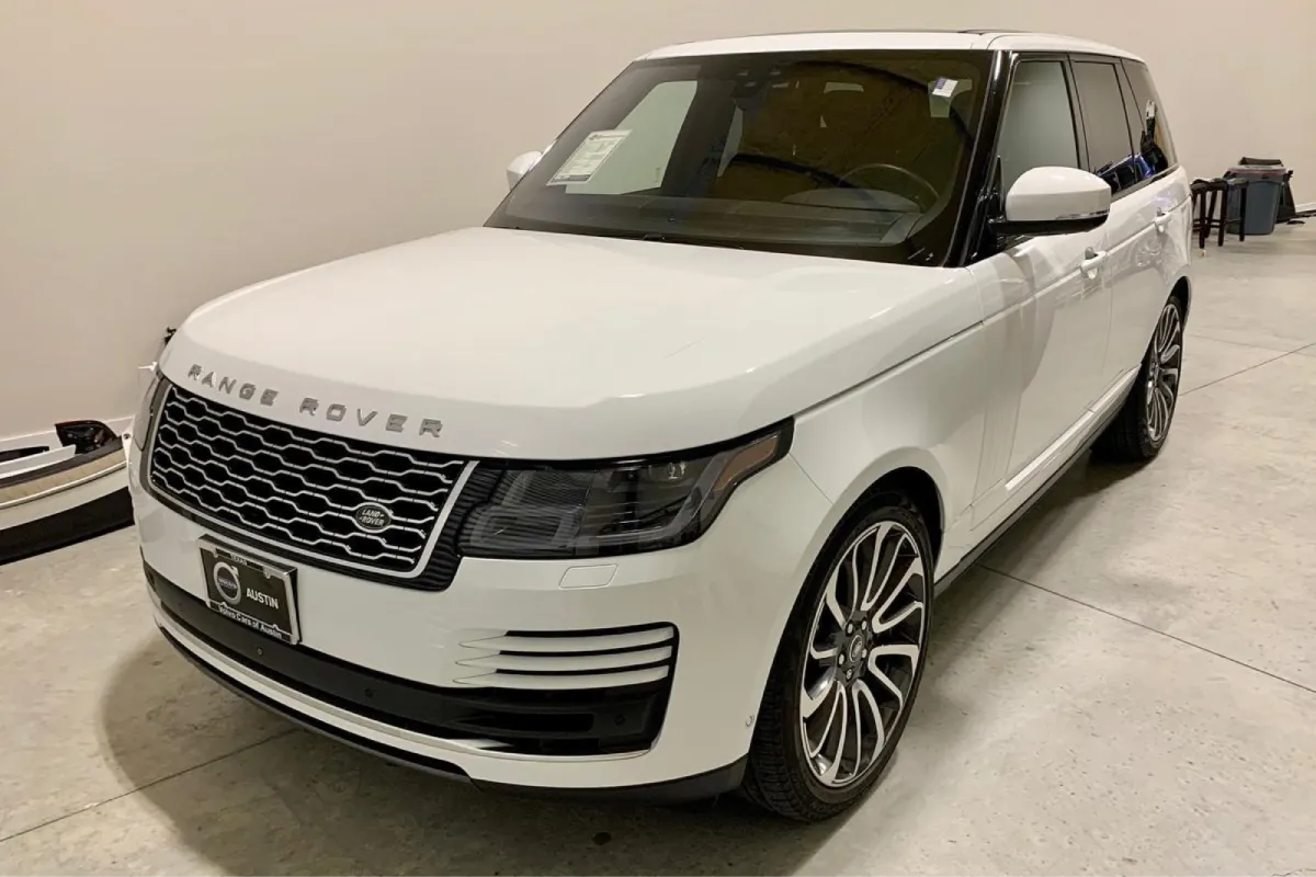 Front view of a white Range Rover, highlighting its grille and elegant styling