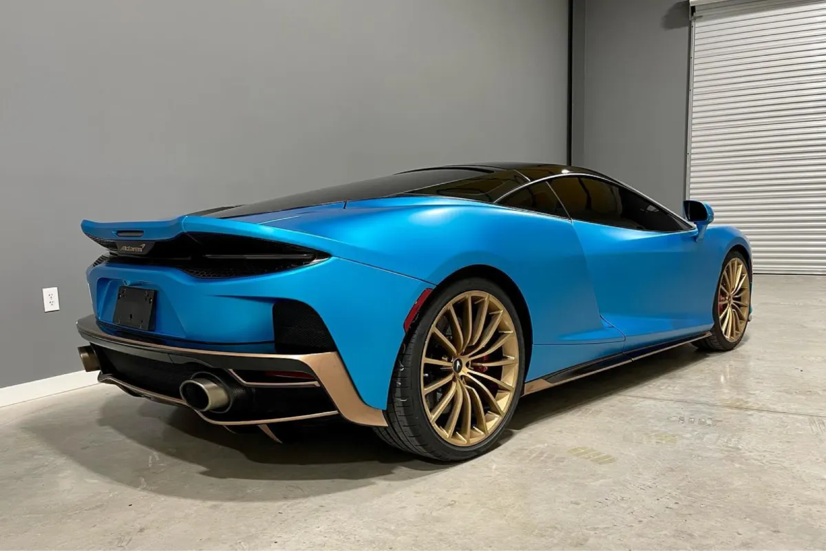 Blue McLaren with a satin vinyl wrap and gold wheels.