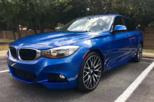Front side view of a blue BMW with restored gloss after paint correction.