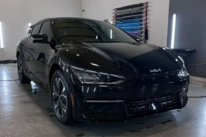 Front view of a black Kia EV protected with paint protection film.