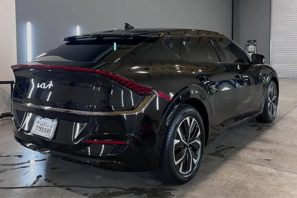 Rear side view of a black Kia EV with paint protection film.