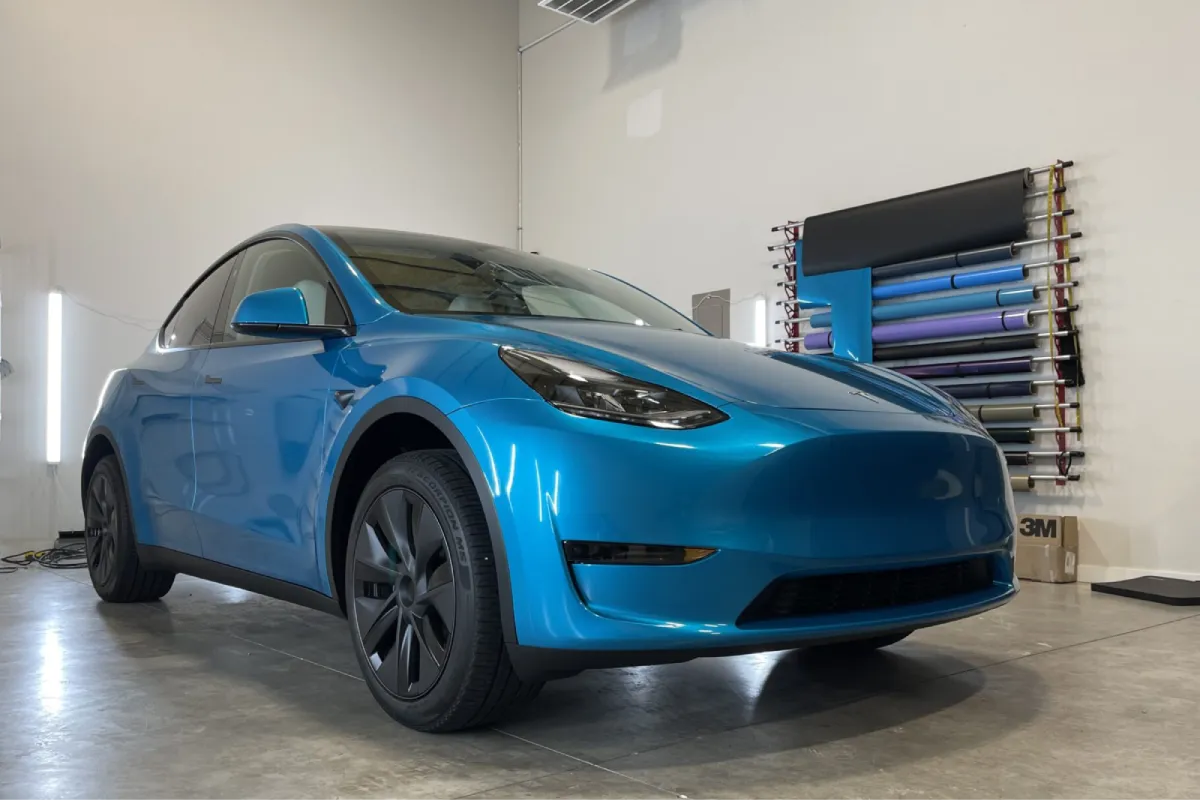 Blue Tesla Model Y with a glossy vinyl wrap.